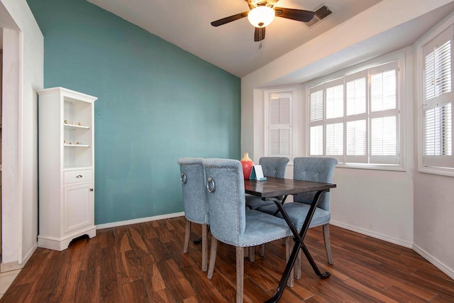 dining room with visible vents, baseboards, vaulted ceiling, and dark wood-style flooring