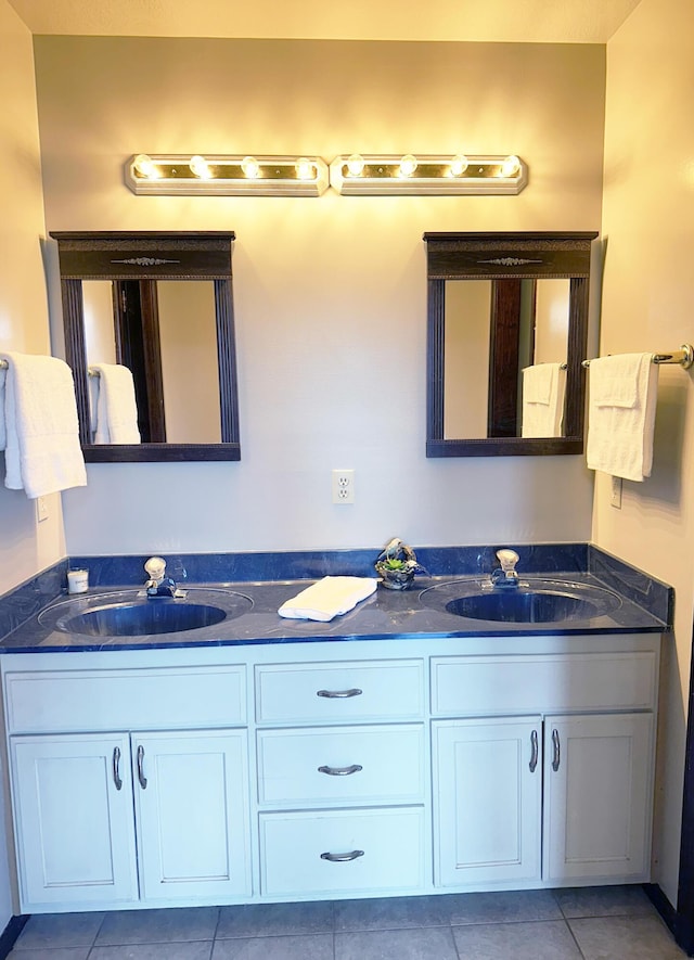 full bathroom with double vanity, a sink, and tile patterned floors