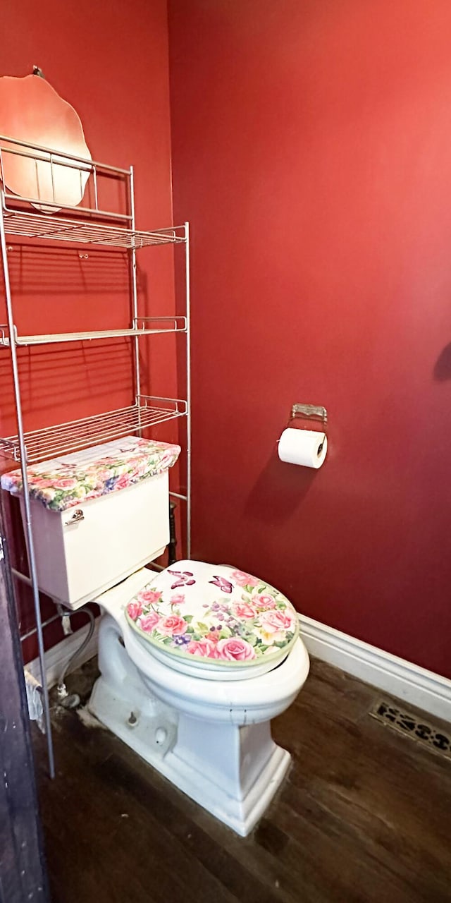 bathroom featuring toilet, wood finished floors, visible vents, and baseboards