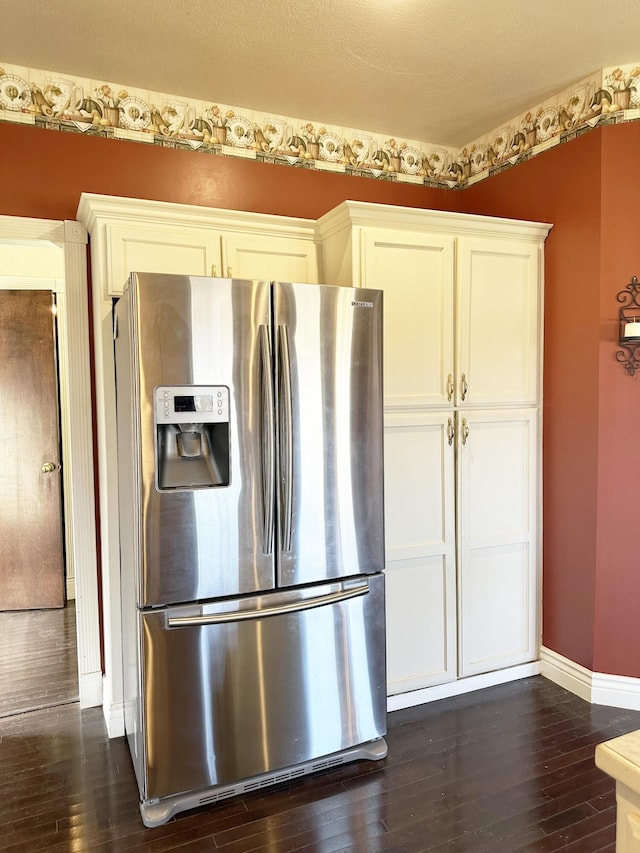 kitchen with dark wood-style flooring, white cabinets, baseboards, and stainless steel fridge with ice dispenser