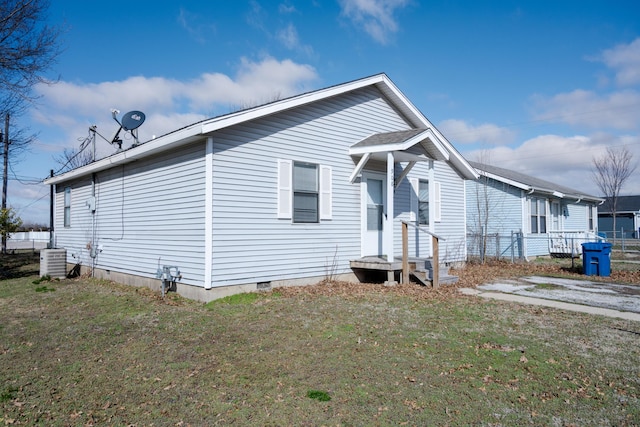 view of front facade featuring central AC, crawl space, and a front yard