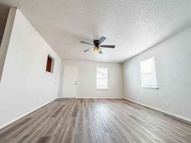 908 Jefferson Ave, Joplin, MO 64801 - empty room featuring a textured ceiling, wood finished floors, a ceiling fan, and baseboards