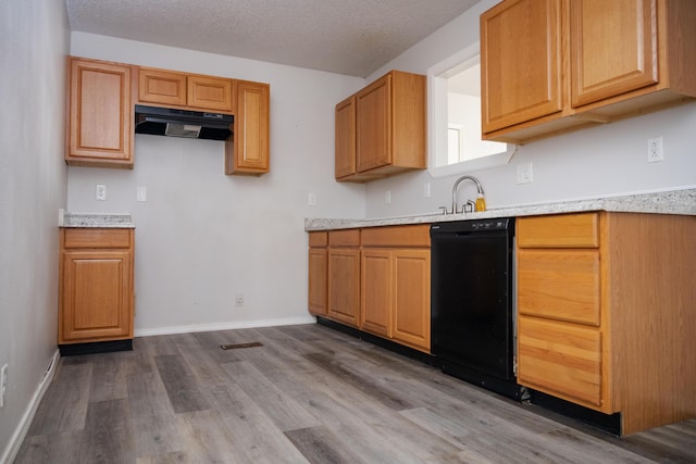 908 Jefferson Ave, Joplin, MO 64801 - kitchen with a textured ceiling, under cabinet range hood, dark wood-style floors, light countertops, and dishwasher