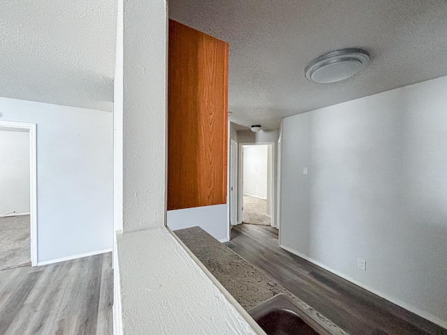 908 Jefferson Ave, Joplin, MO 64801 - hallway featuring a textured ceiling, baseboards, and wood finished floors