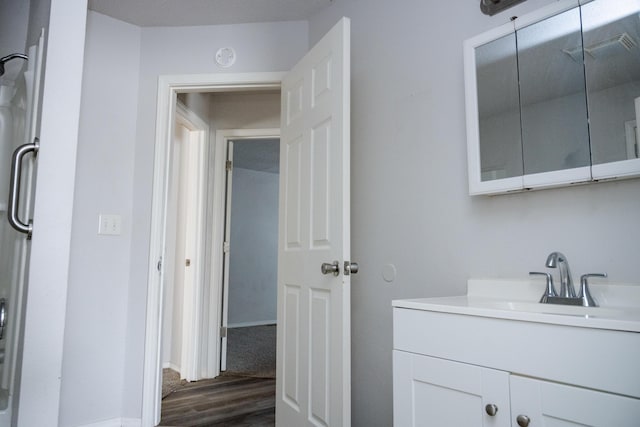 908 Jefferson Ave, Joplin, MO 64801 - bathroom with baseboards, visible vents, wood finished floors, and vanity