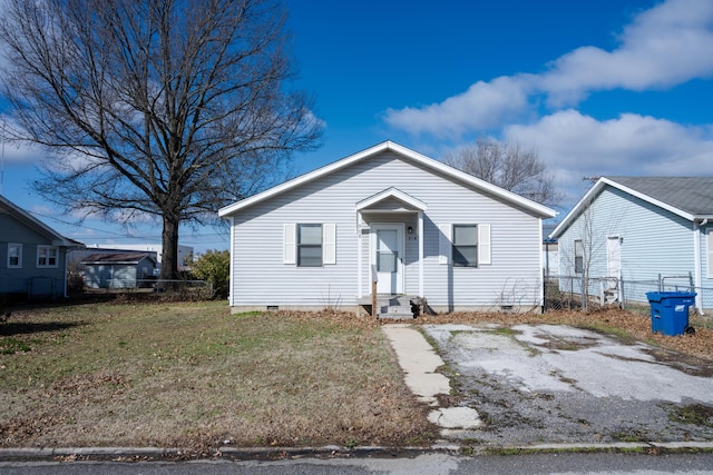 bungalow with entry steps, crawl space, fence, and a front lawn