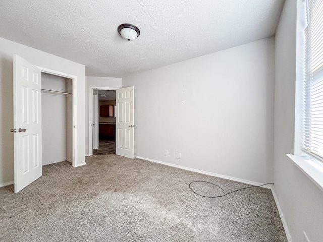 908 Jefferson Ave, Joplin, MO 64801 - unfurnished bedroom with carpet floors, a textured ceiling, baseboards, and a closet