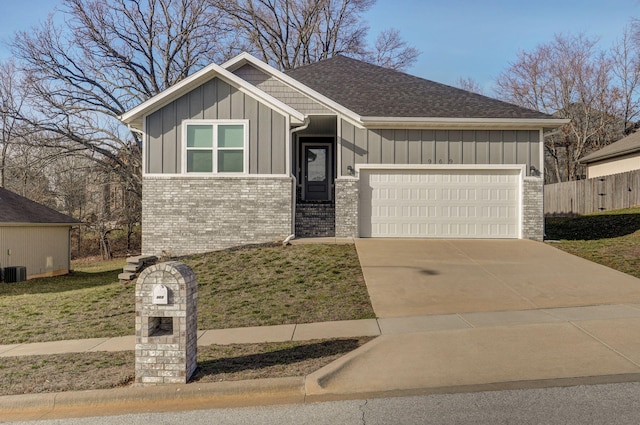 view of front of house featuring an attached garage, brick siding, driveway, a front lawn, and board and batten siding