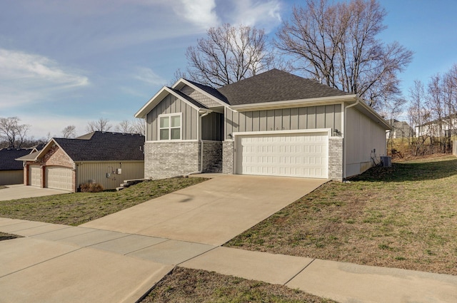 view of front of house with an attached garage, brick siding, driveway, a front lawn, and board and batten siding