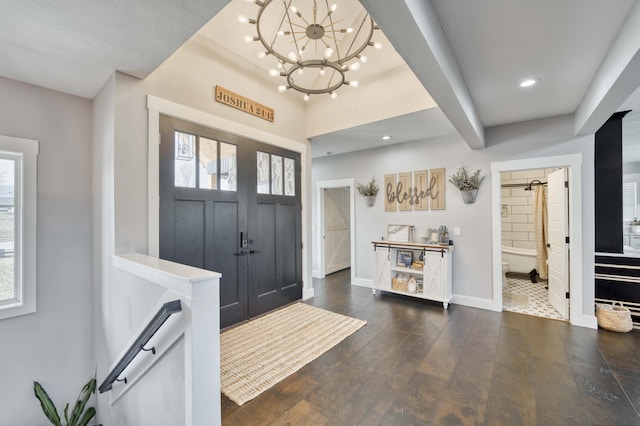 foyer with recessed lighting, a notable chandelier, dark wood finished floors, and baseboards