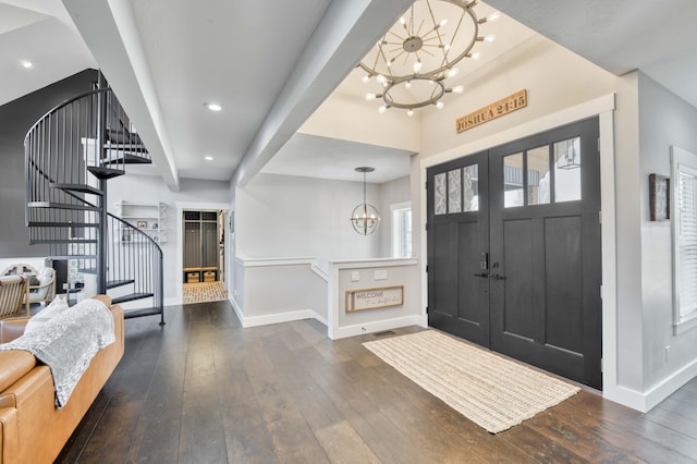 foyer entrance with a chandelier, wood-type flooring, stairway, and baseboards