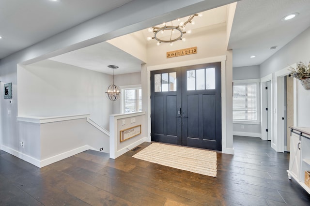 foyer entrance with a chandelier, baseboards, dark wood finished floors, and a healthy amount of sunlight