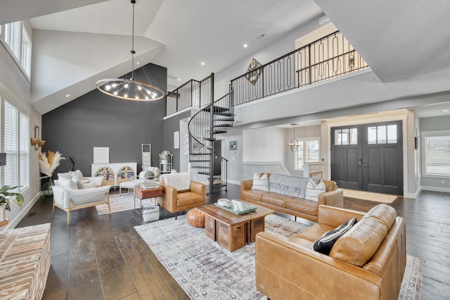 living area with an inviting chandelier, stairs, and hardwood / wood-style floors