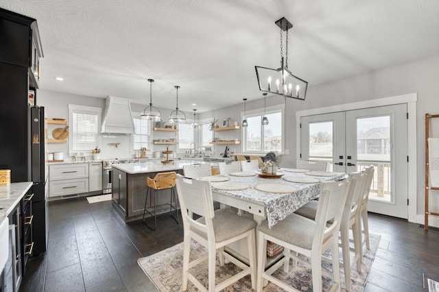 dining area with dark wood-style floors, french doors, and a textured ceiling