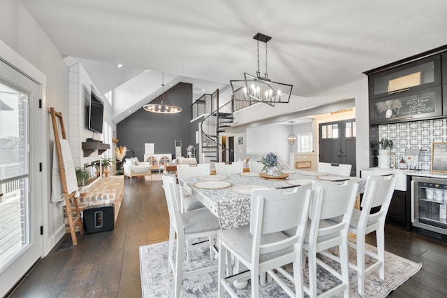 dining area featuring a chandelier, wine cooler, dark wood-style flooring, and stairway