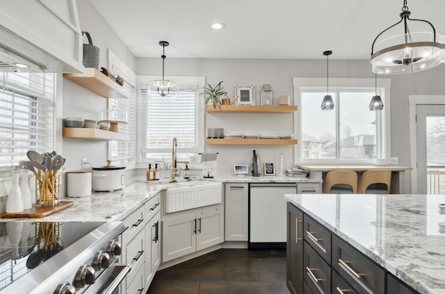 kitchen featuring hanging light fixtures, stainless steel range oven, white dishwasher, and open shelves