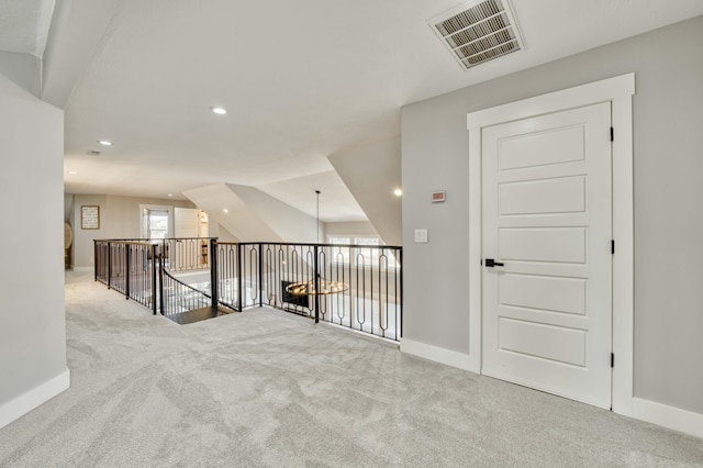 carpeted empty room featuring baseboards, visible vents, and recessed lighting