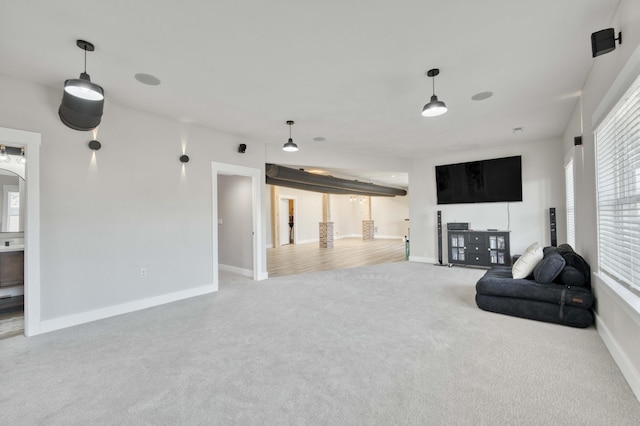 carpeted living area with baseboards