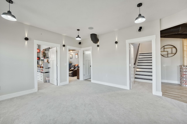 interior space with stairs, baseboards, and light colored carpet