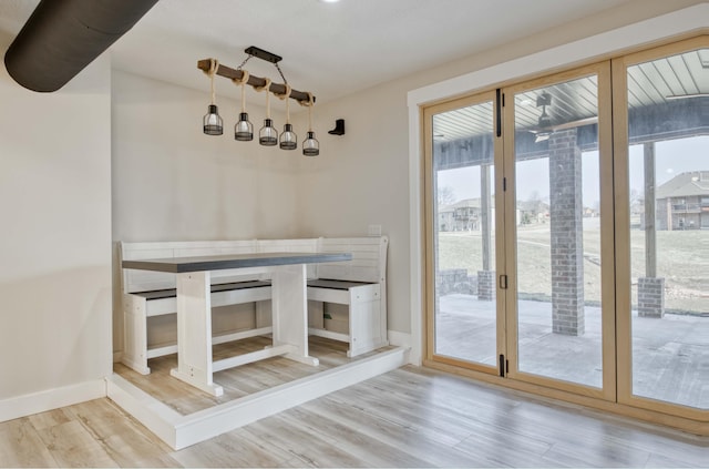 unfurnished dining area with baseboards and wood finished floors