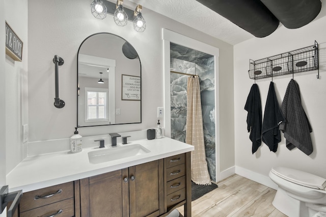 full bath with curtained shower, toilet, wood finished floors, vanity, and baseboards