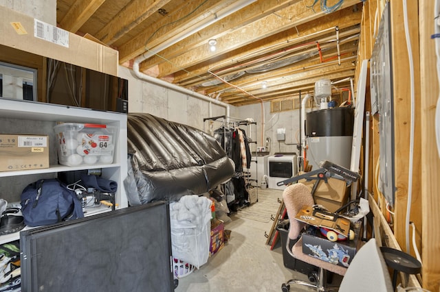 unfinished below grade area featuring water heater and washer / clothes dryer