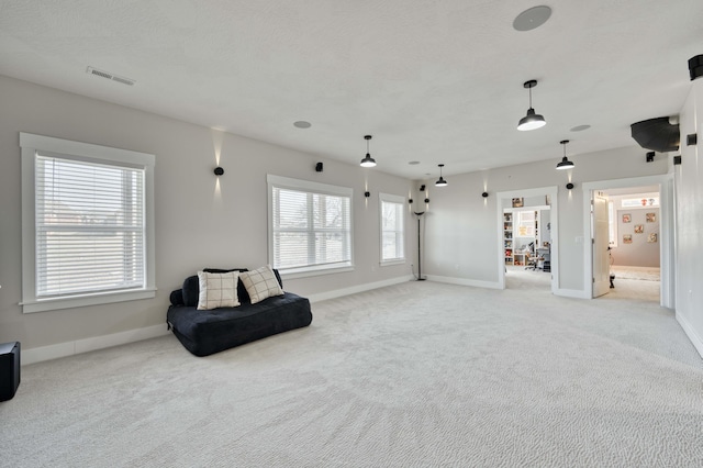 sitting room featuring light carpet, a textured ceiling, visible vents, and baseboards