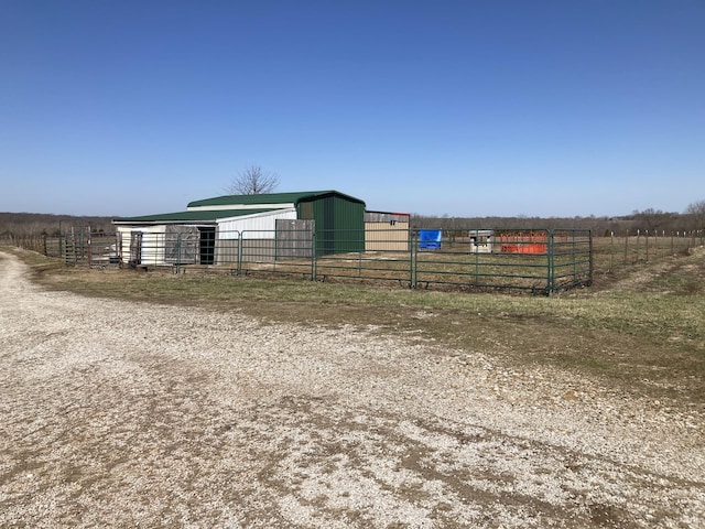 view of yard featuring a rural view, an exterior structure, and an outbuilding