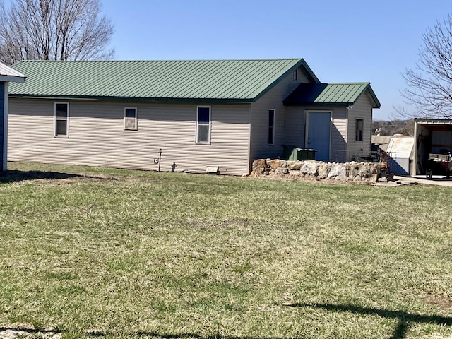 view of home's exterior featuring metal roof and a lawn