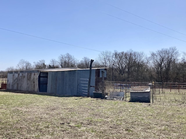 view of yard with an outdoor structure, fence, and an outbuilding