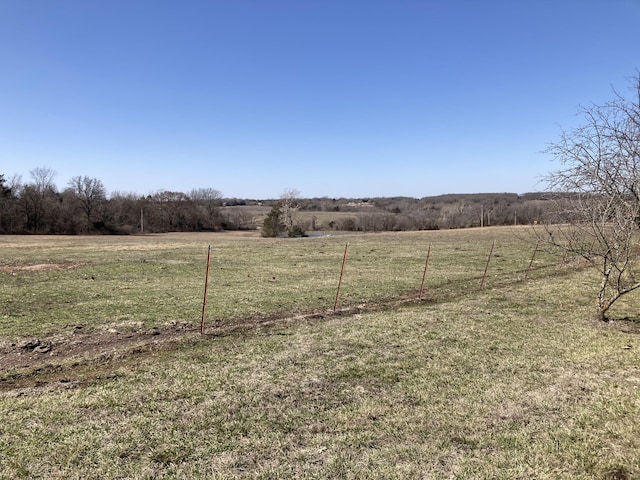 view of yard featuring a rural view and fence