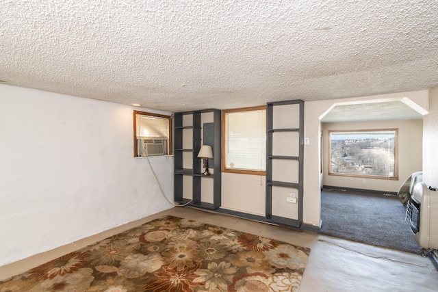 empty room featuring baseboards, cooling unit, and a textured ceiling