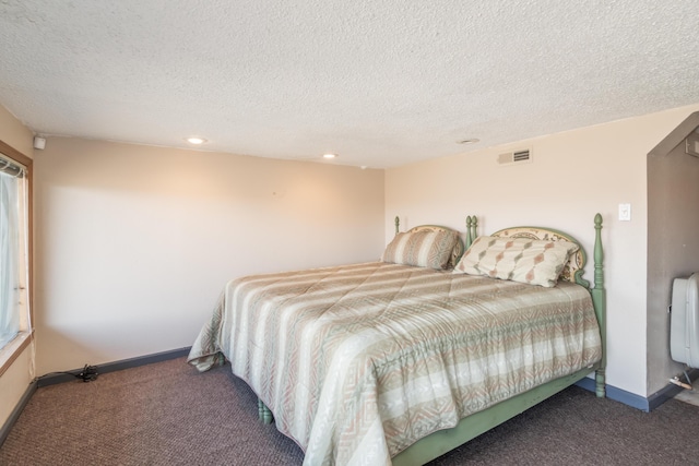 bedroom featuring carpet, visible vents, a textured ceiling, and baseboards