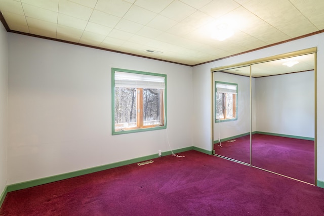 unfurnished bedroom with ornamental molding, carpet flooring, visible vents, and baseboards