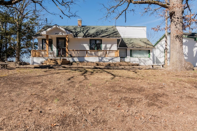 view of front of house featuring covered porch and a chimney