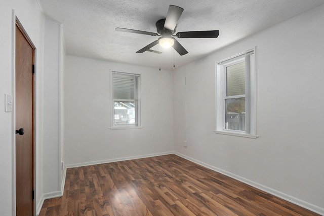 empty room featuring dark wood-style floors, ceiling fan, a textured ceiling, and baseboards