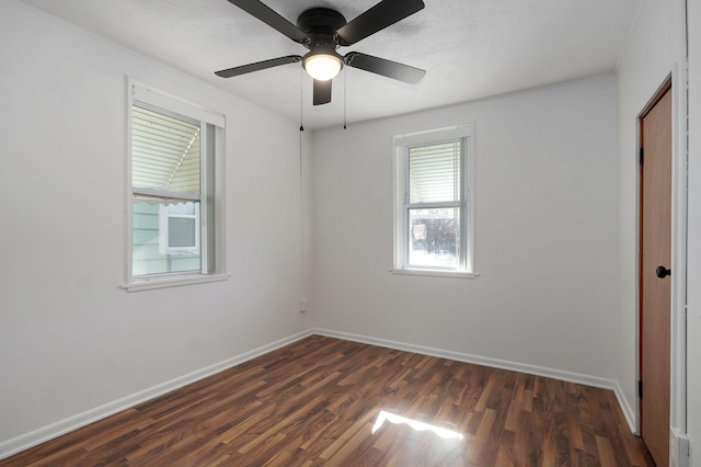 unfurnished bedroom featuring a textured ceiling, dark wood-style flooring, a ceiling fan, and baseboards