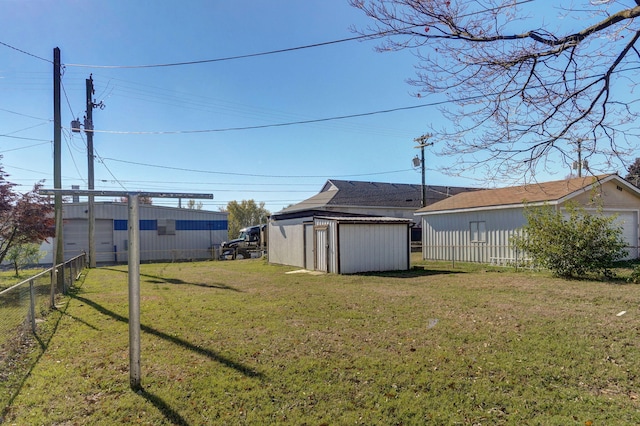 view of yard with a storage unit, fence, and an outbuilding