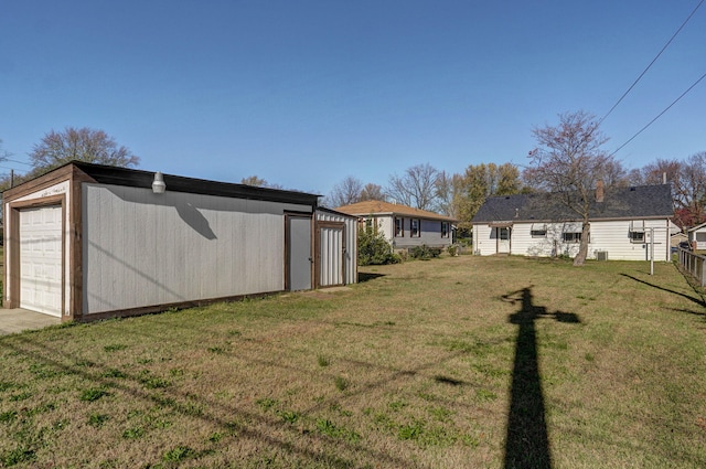 view of yard featuring a garage and an outbuilding