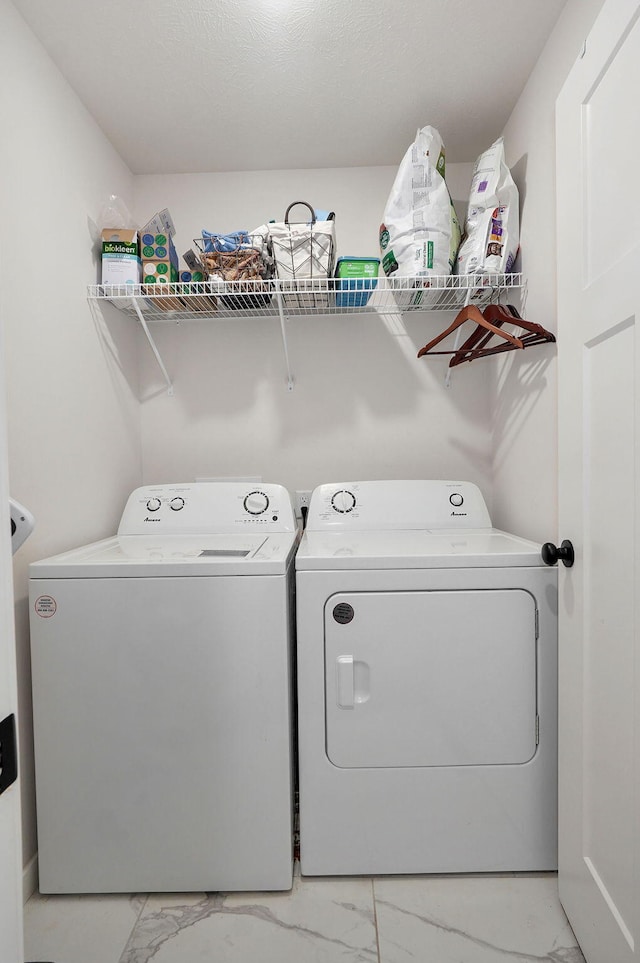 washroom featuring marble finish floor, laundry area, and washer and dryer