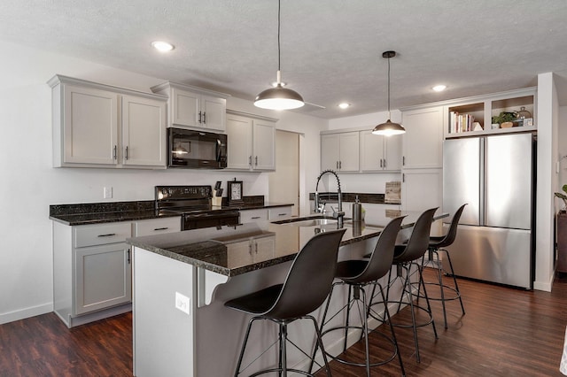kitchen with dark wood-type flooring, a textured ceiling, black appliances, open shelves, and a sink