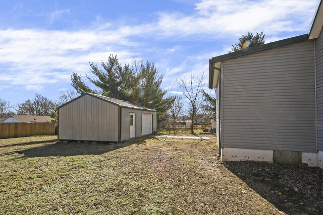 view of yard with an outdoor structure, a garage, and fence