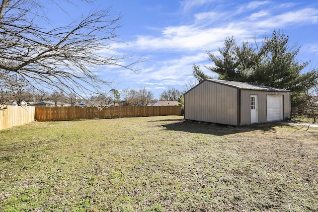 view of yard featuring an outbuilding, fence, and a detached garage