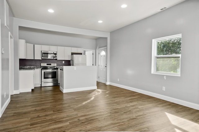 kitchen featuring white cabinets, dark wood-style floors, appliances with stainless steel finishes, and baseboards