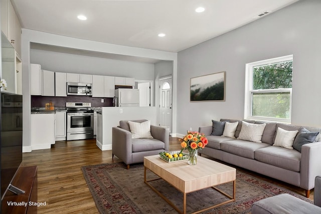 living room with baseboards, dark wood-style floors, visible vents, and recessed lighting
