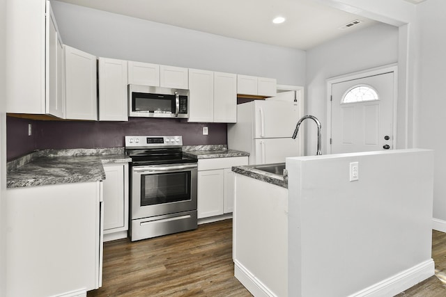 kitchen with dark wood finished floors, white cabinetry, a sink, and stainless steel appliances