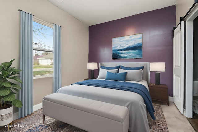 bedroom featuring baseboards and a barn door