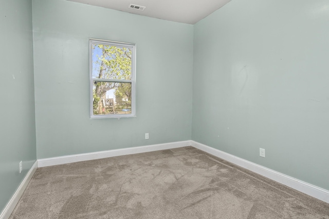 carpeted spare room with baseboards and visible vents