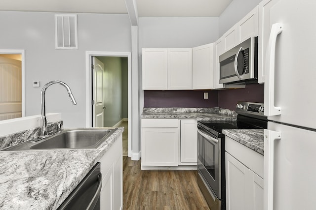 kitchen with white cabinets, visible vents, appliances with stainless steel finishes, dark wood-type flooring, and a sink