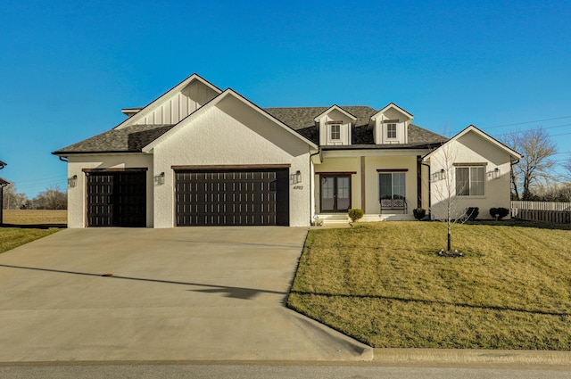 modern inspired farmhouse featuring a garage, a shingled roof, driveway, a front lawn, and board and batten siding